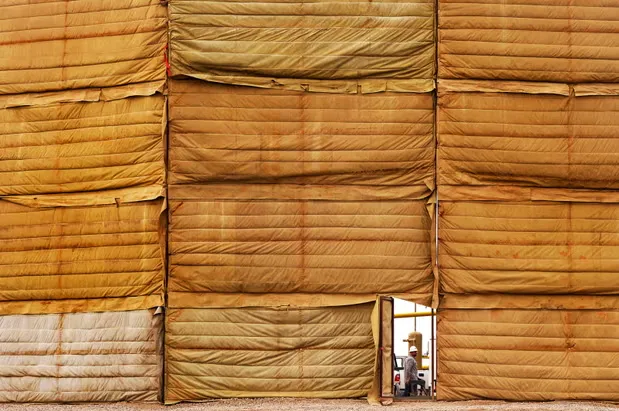 An oilfield worker walks past an open door at a drill pad in Windsor Colorado RJ Sangosti